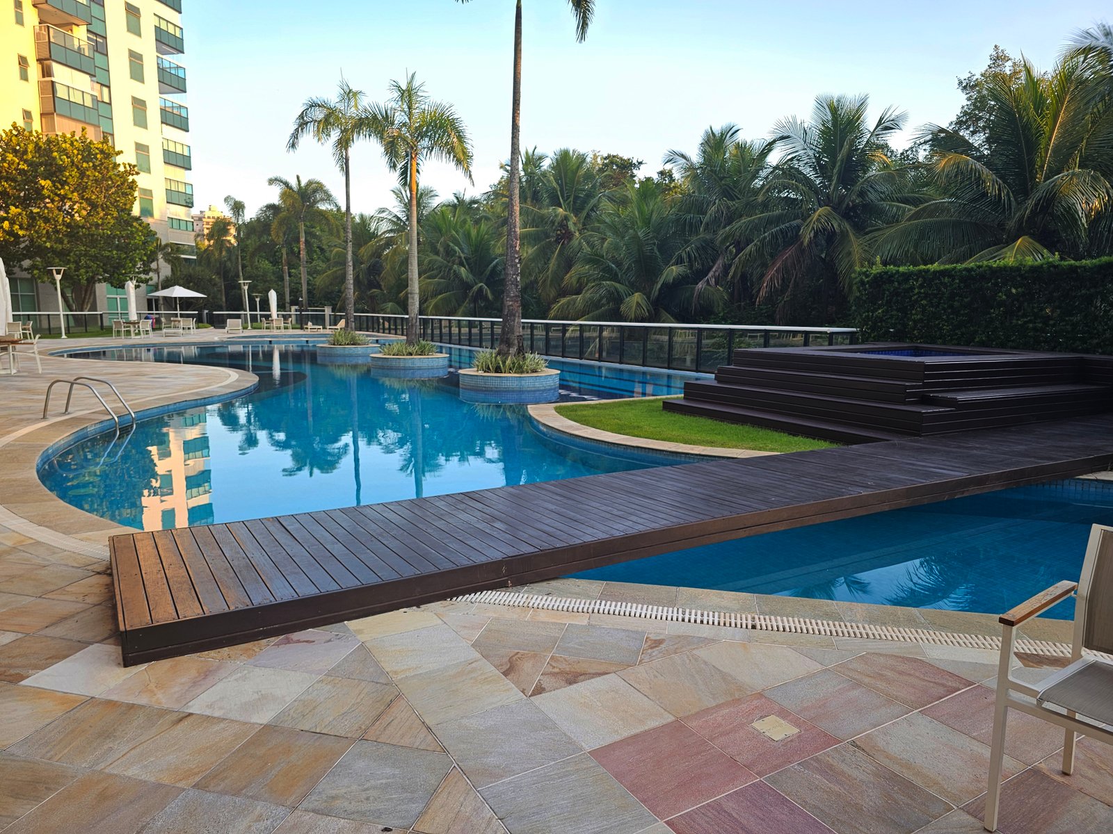 Piscina com deck de madeira e área lounge