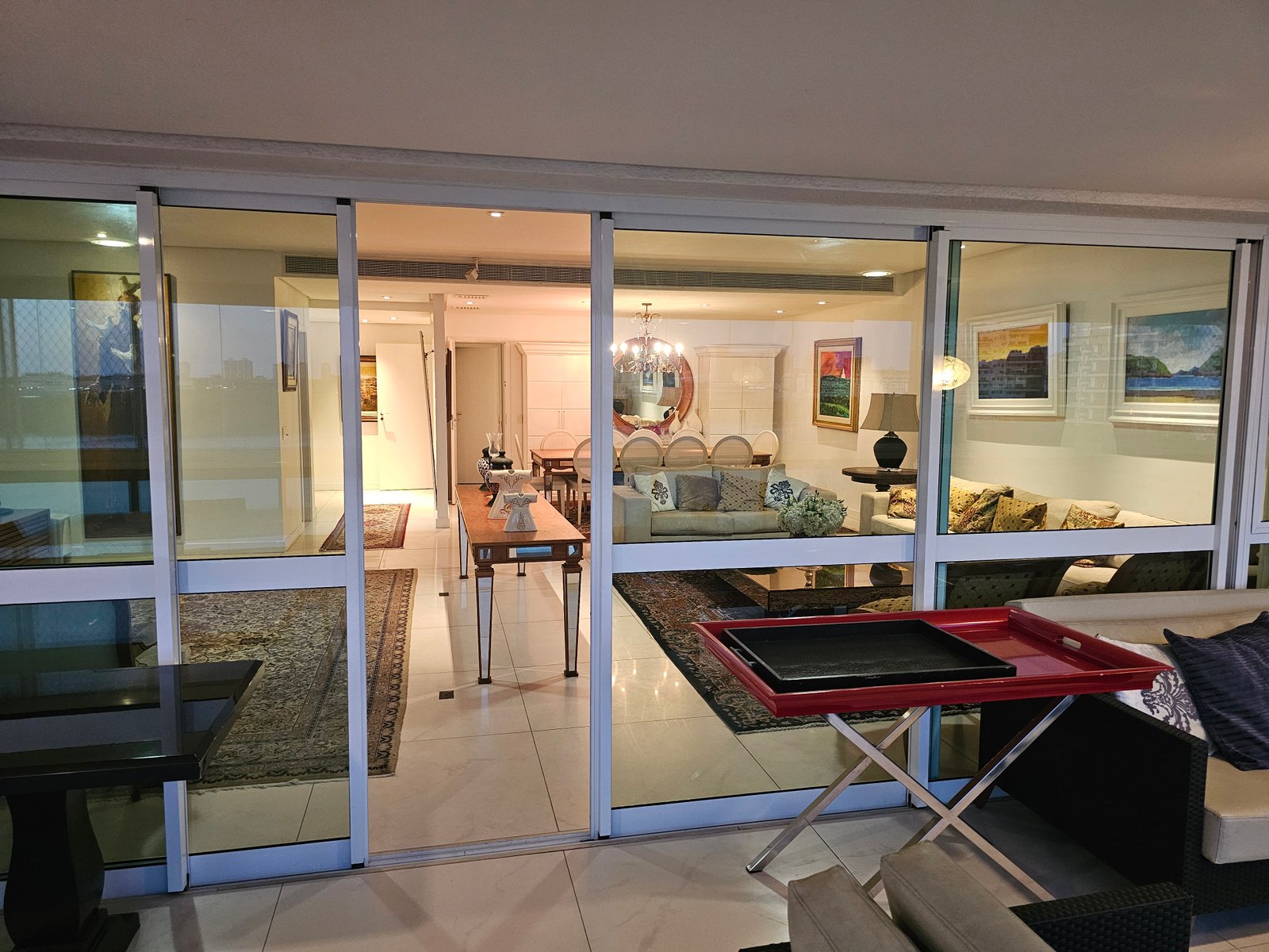 Vista da varanda para a sala através das portas de vidro